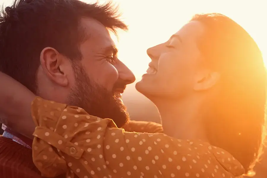 A couple embracing with the sunset behind them. Schedule Bioidentical Hormone Pellet Therapy from Blue Skye Health and Wellness in Tampa.