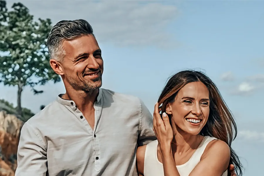 A middle-aged couple walking outside on a sunny day smiling after receiving expert BPC-157 Peptide Therapy by Blue Skye Health and Wellness in Tampa.