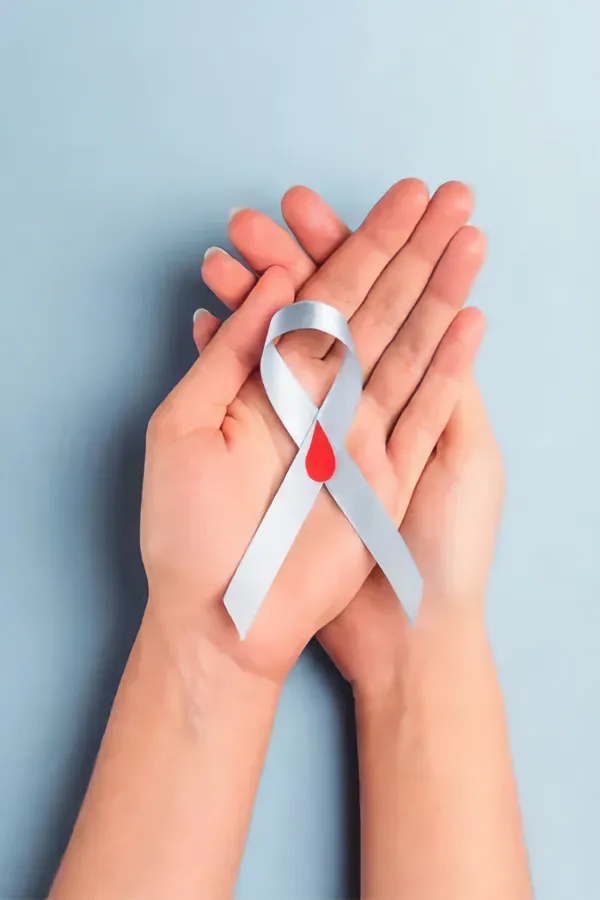 A woman's hands holding a white ribbon with a red drop symbol on it, symbolizing diabetes treatment from Blue Skye Health and Wellness in Tampa.